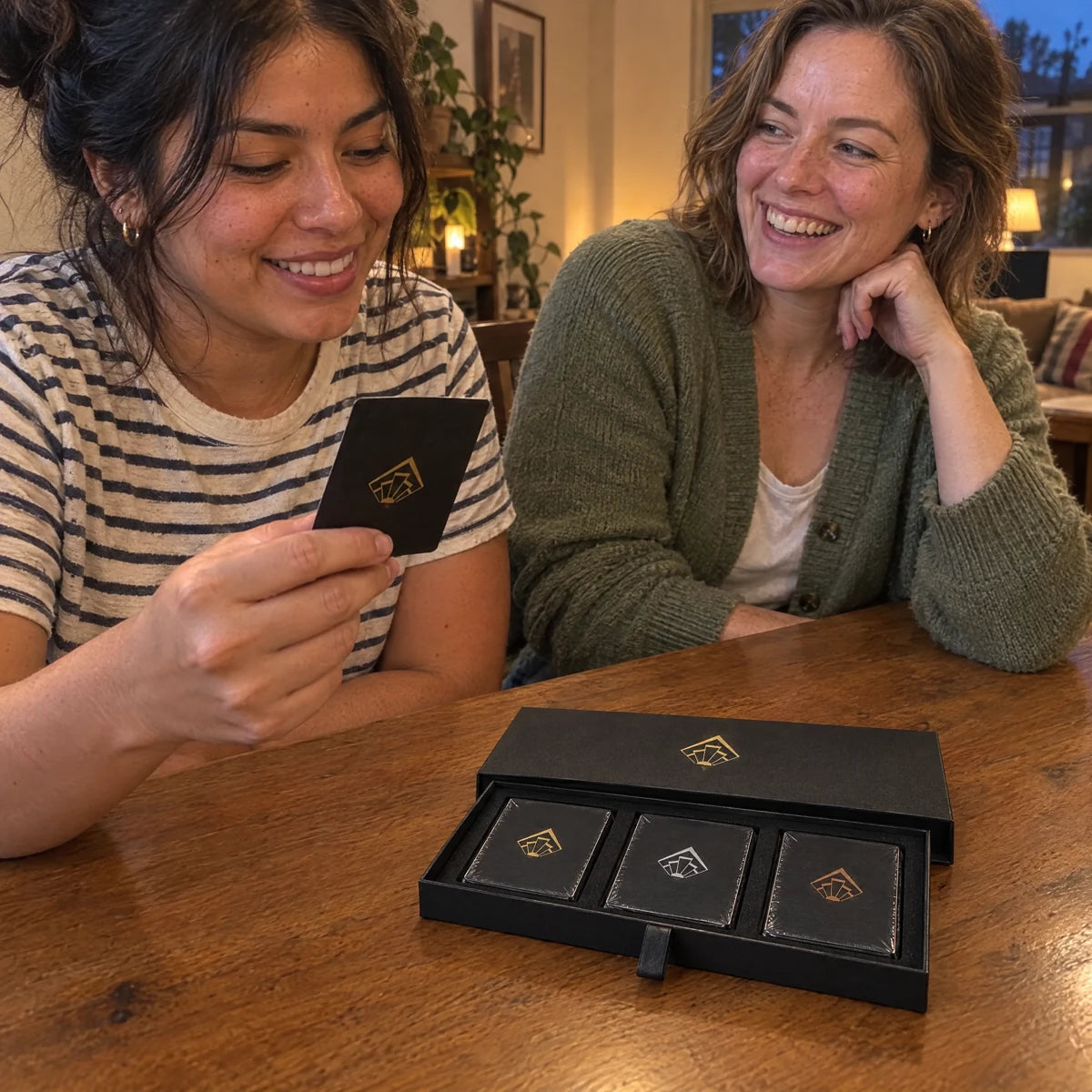 Two women sharing a card-game moment at their dining table.