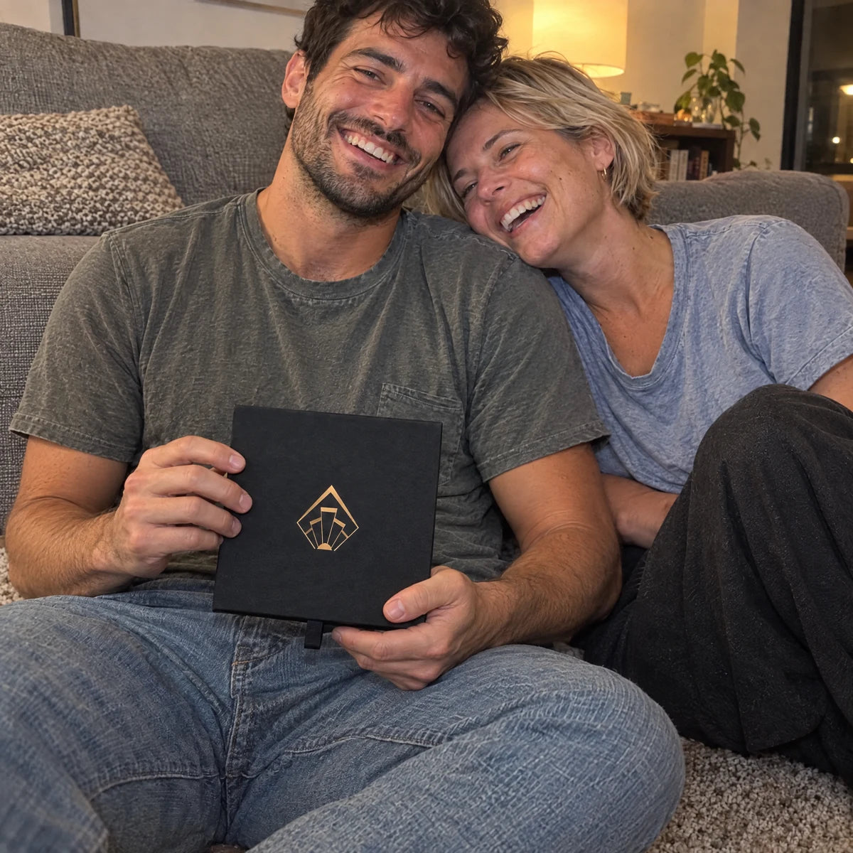Couple laughing together with the closed Twosome Poster carry box.